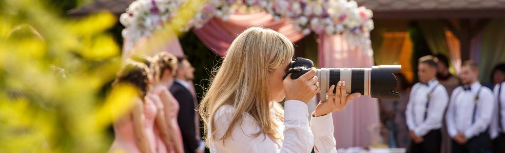 Professional wedding photographer capturing images during a wedding ceremony.