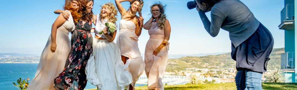 Wedding photographer capturing a bridal party portrait during an outdoor wedding celebration.