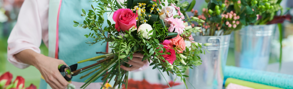 Florist creating a colorful flower arrangement in a flower shop.