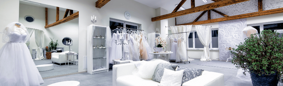 Wedding dresses displayed on racks inside a bridal boutique showroom