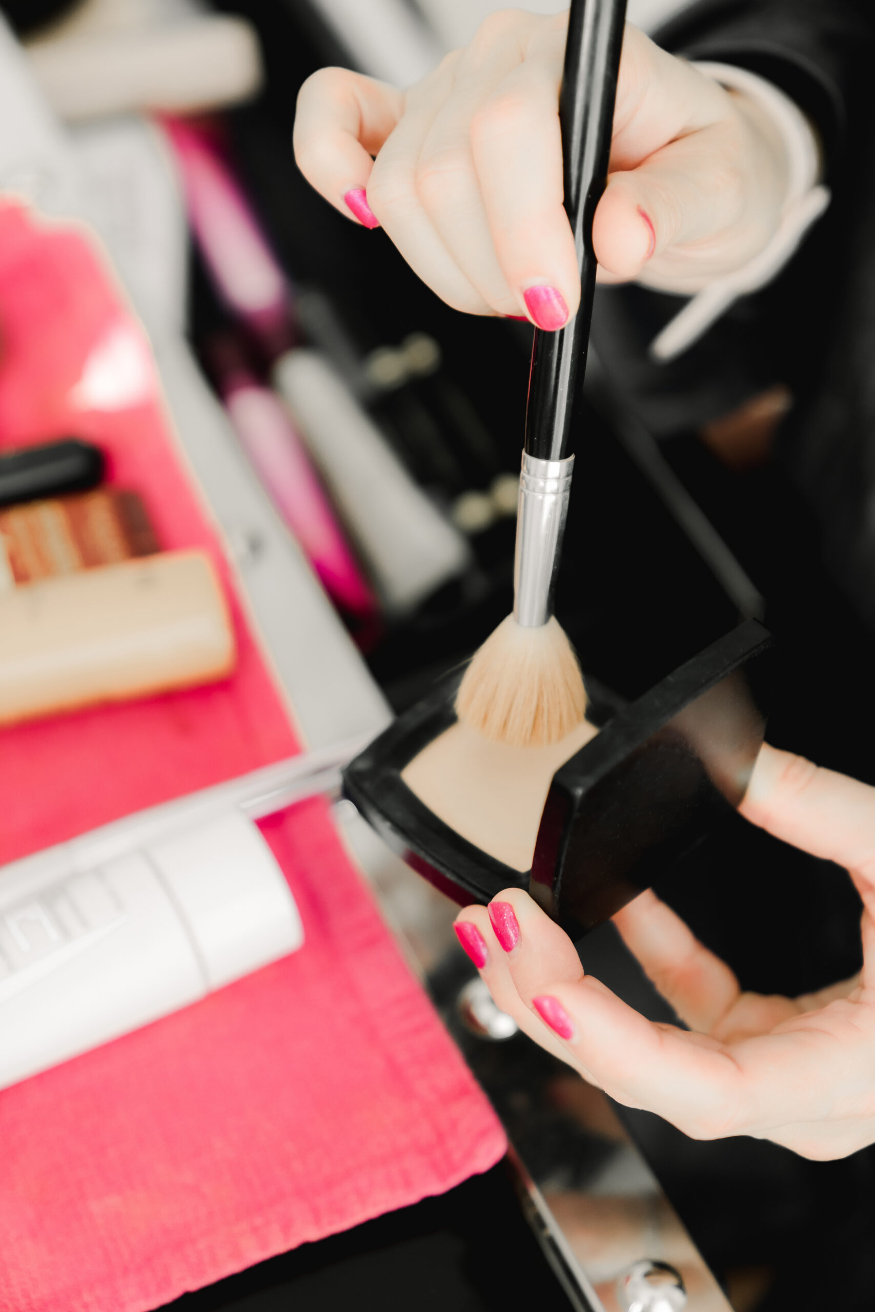 bridal makeup artist applying face powder with brush for flawless finish