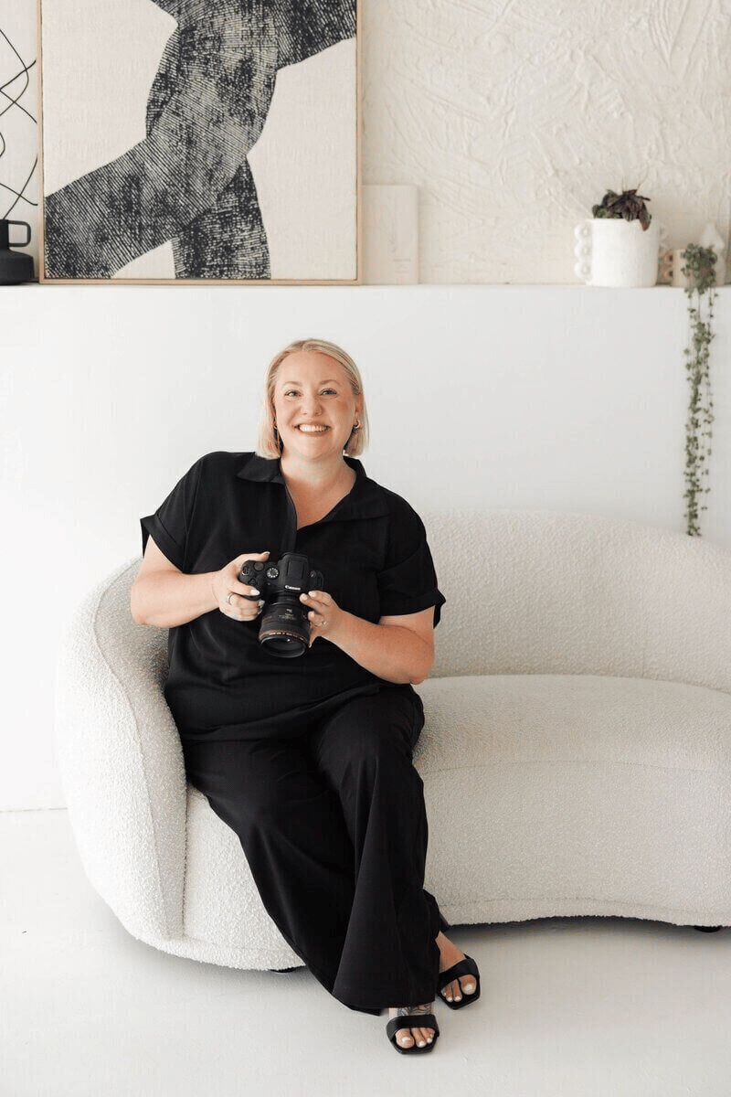 St Augustine wedding photographer Shandi sitting on a couch holding her camera